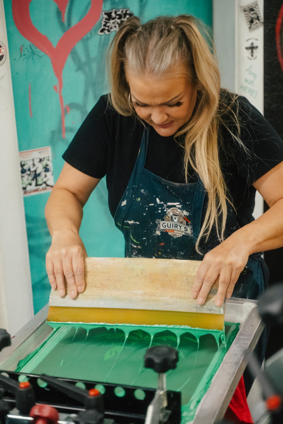 A Street2Life crew member printing a shirt by hand
